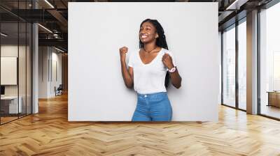 Portrait of a happy young african woman celebrating success isolated over gray background Wall mural